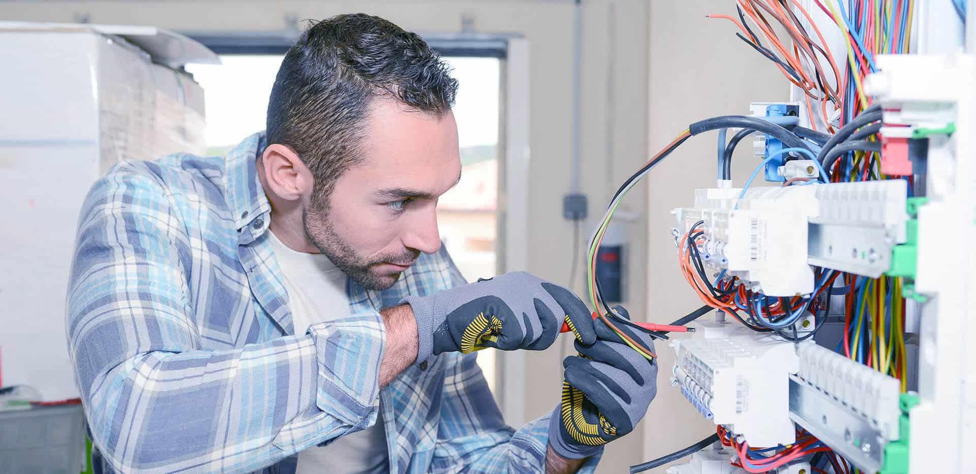 Electrician Working On Switchboard Of House Building Construction Site