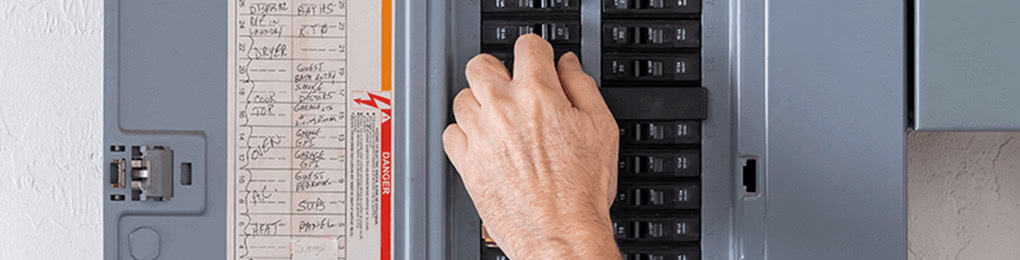 person switching breaker in open electric panel
