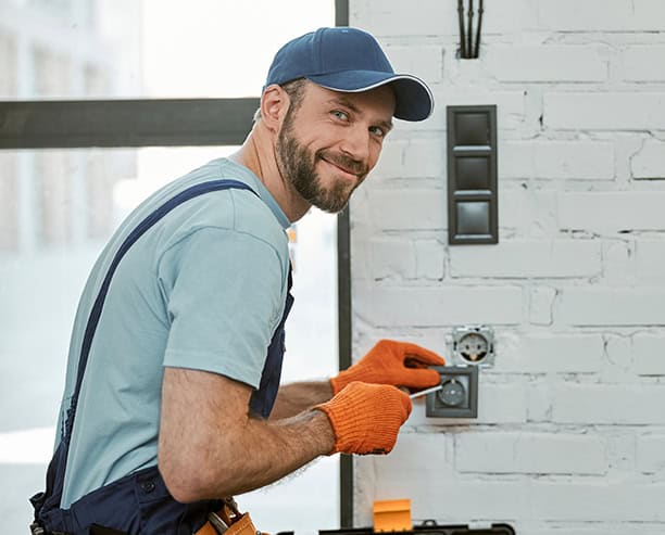 Electrician Installing Wall Outlet In Modern Home