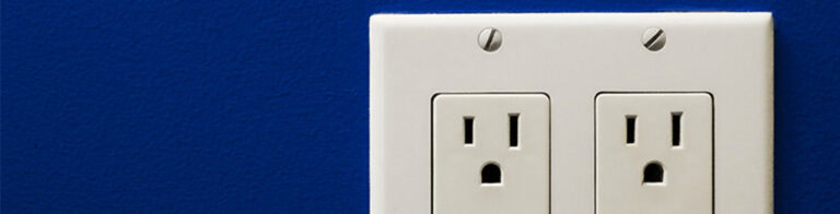 two three-prong outlets on a blue wall